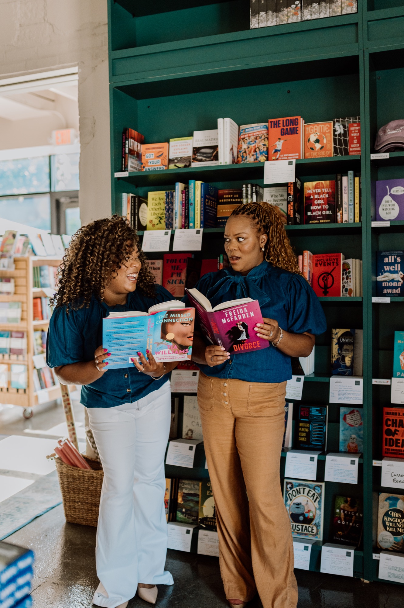 Tee and Tam comparing two open books in a bookstore