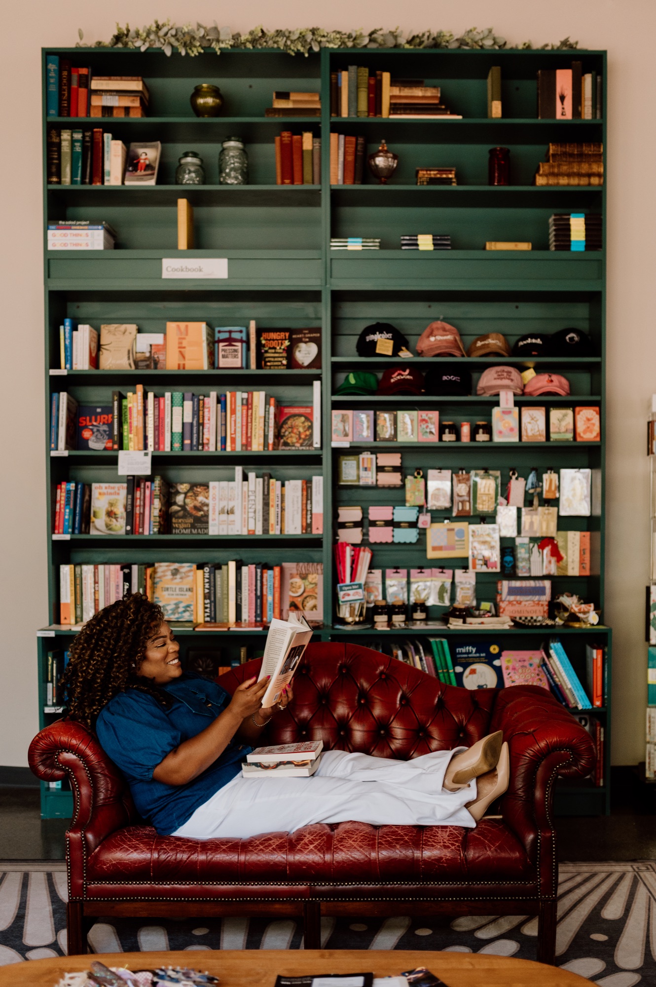 Tee reading on a bookstore couch