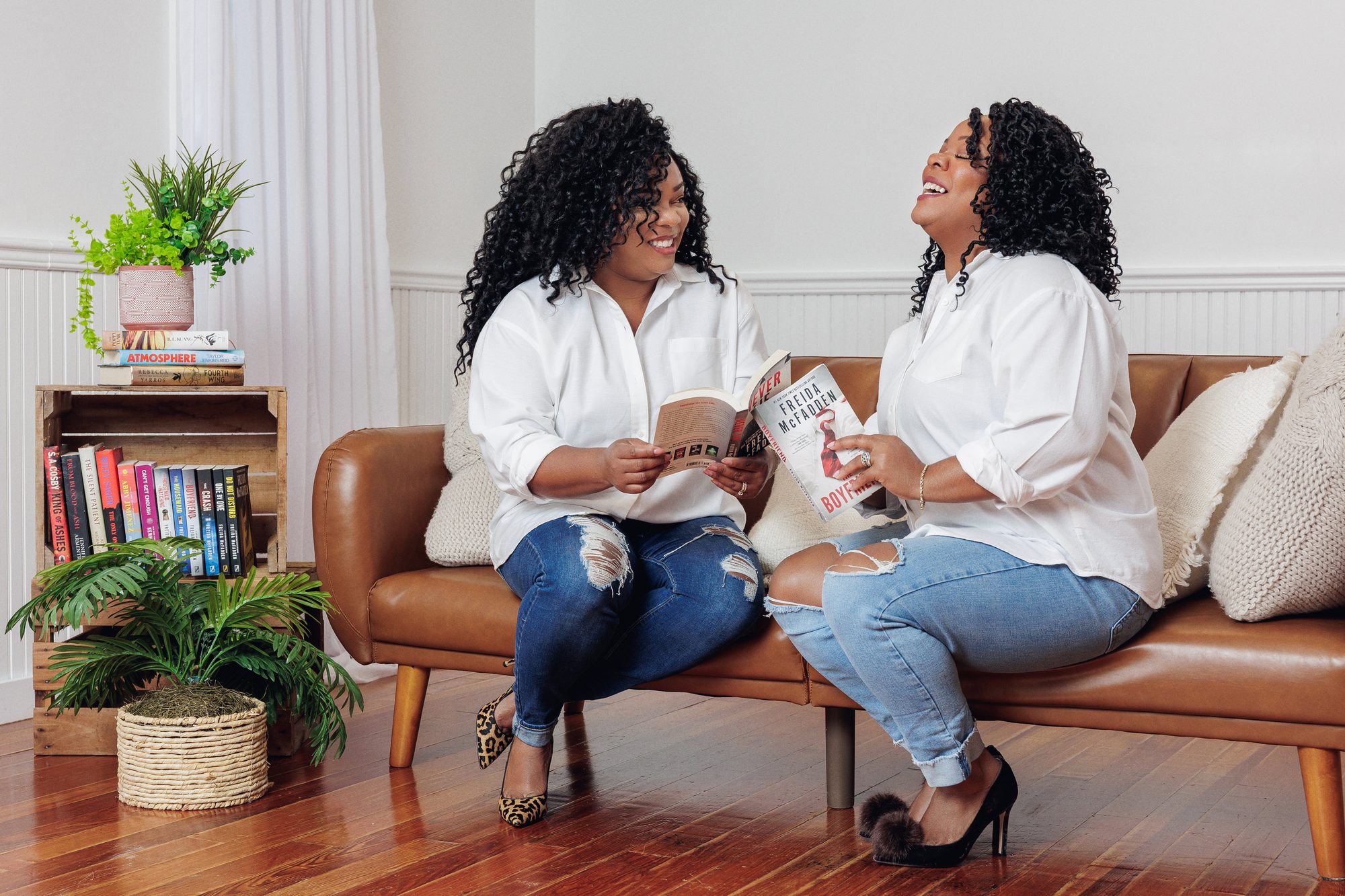 Tee and Tam laughing together over thrillers on their couch